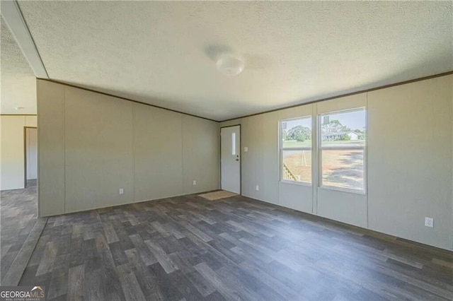 spare room featuring dark wood finished floors and a textured ceiling