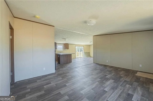 unfurnished living room with crown molding, dark wood-style flooring, and a textured ceiling