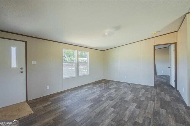 kitchen featuring brown cabinetry, dark wood-style floors, open floor plan, freestanding refrigerator, and light countertops