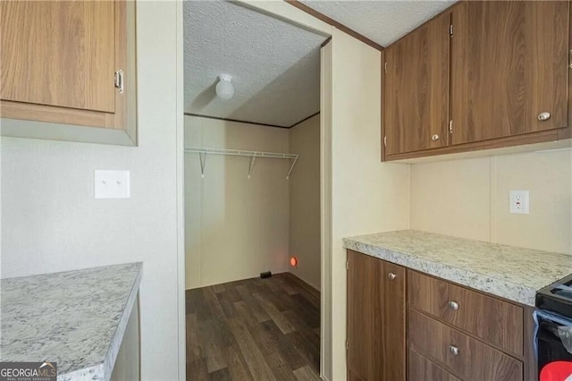 laundry room featuring a textured ceiling and dark wood-type flooring