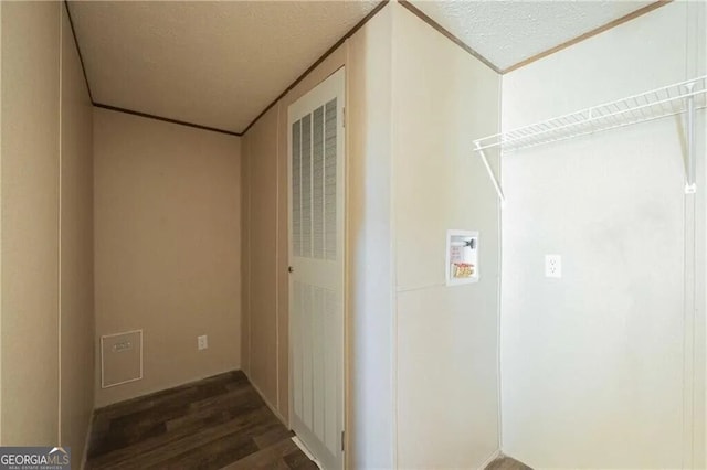 clothes washing area featuring dark wood-style floors, washer hookup, laundry area, and a textured ceiling