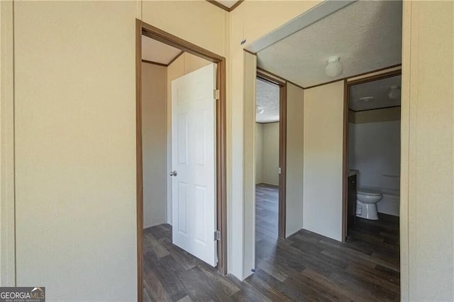 hall with dark wood-style floors and a textured ceiling