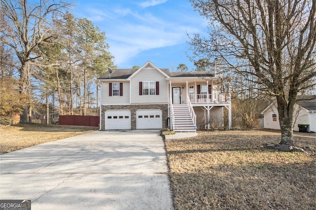 view of front of home with a garage, covered porch, and a front yard