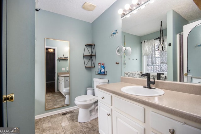118 Gilberts Way, Temple, GA 30179 - bathroom with toilet, vanity, a textured ceiling, baseboards, and stone finish flooring