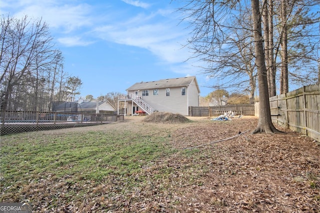 118 Gilberts Way, Temple, GA 30179 - back of house featuring a trampoline, stairway, and a deck