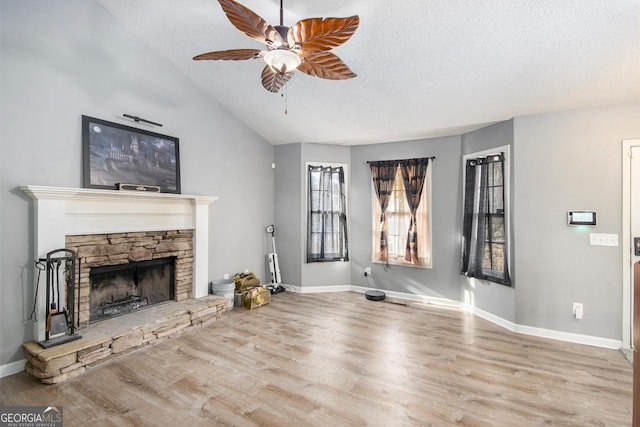 118 Gilberts Way, Temple, GA 30179 - unfurnished living room with ceiling fan, a textured ceiling, wood finished floors, a stone fireplace, and lofted ceiling