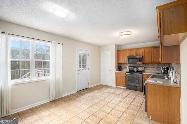 kitchen featuring sink, backsplash, range with electric cooktop, and a textured ceiling