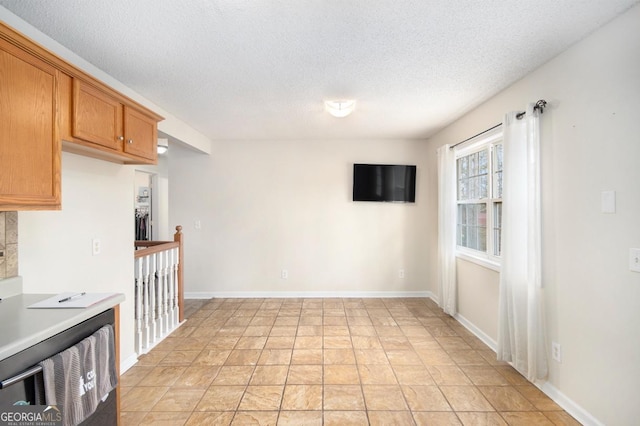 118 Gilberts Way, Temple, GA 30179 - kitchen with a textured ceiling, light countertops, brown cabinets, and baseboards