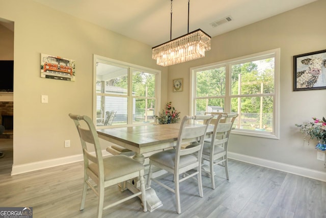 dining room with wood-type flooring and an inviting chandelier