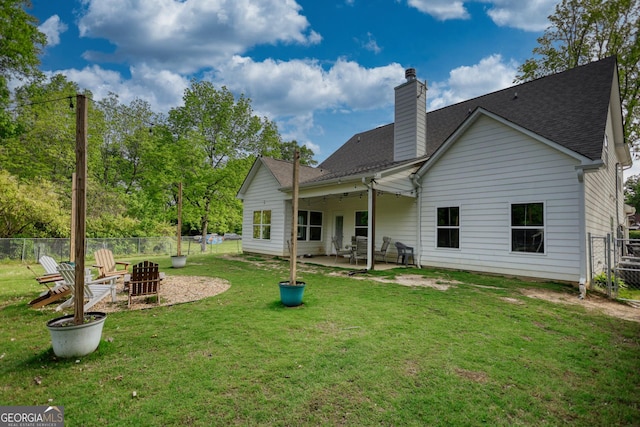 rear view of house with a yard, an outdoor fire pit, and a patio