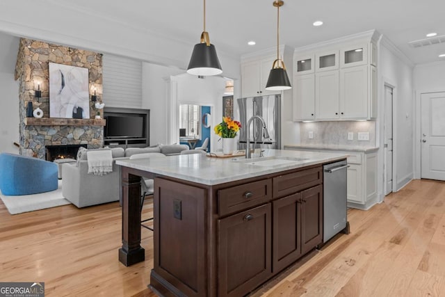 kitchen featuring sink, decorative light fixtures, a breakfast bar area, and white cabinets