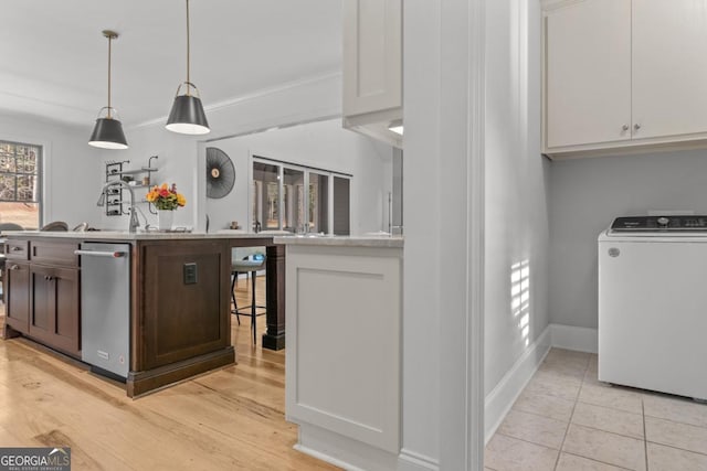 bar featuring white cabinetry, ornamental molding, washer / clothes dryer, decorative light fixtures, and stainless steel dishwasher