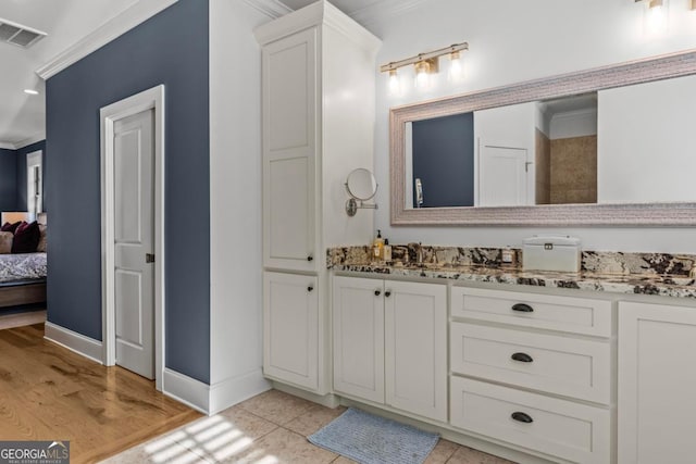 bathroom featuring vanity, hardwood / wood-style floors, and ornamental molding