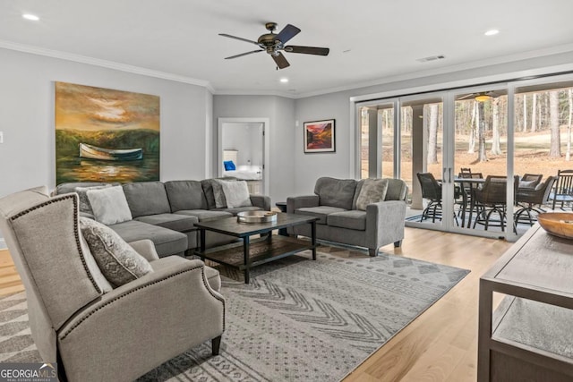 living room with crown molding, ceiling fan, and light hardwood / wood-style flooring