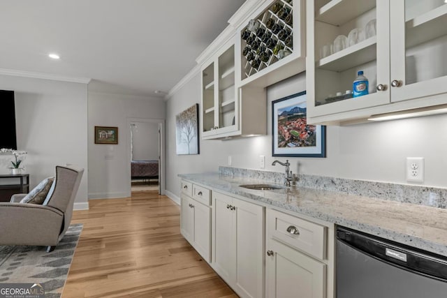 kitchen with white cabinetry, stainless steel dishwasher, crown molding, and sink