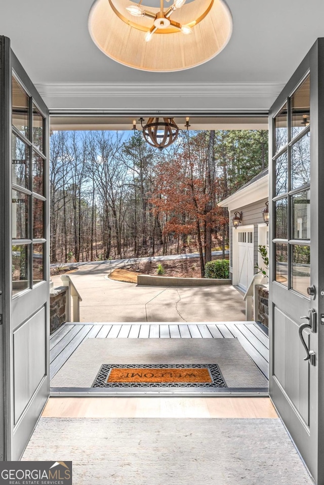 entryway with expansive windows, ornamental molding, and hardwood / wood-style floors