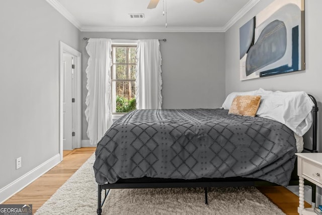 bedroom with ornamental molding, light hardwood / wood-style floors, and ceiling fan