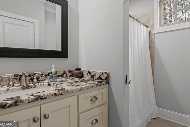 bathroom with walk in shower, vanity, and tile patterned flooring