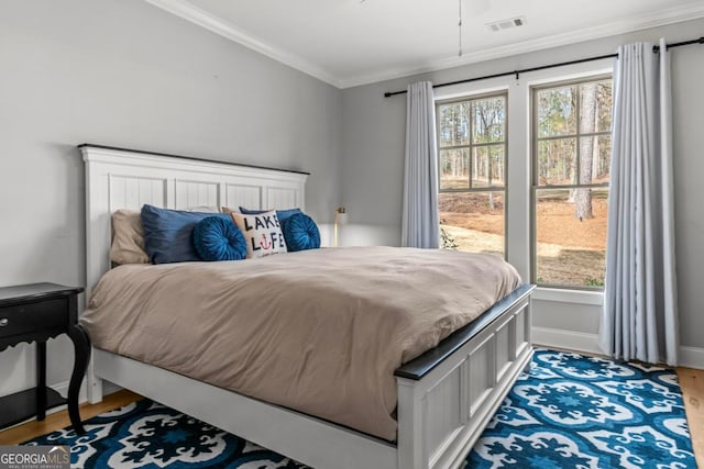 bedroom with wood-type flooring and ornamental molding