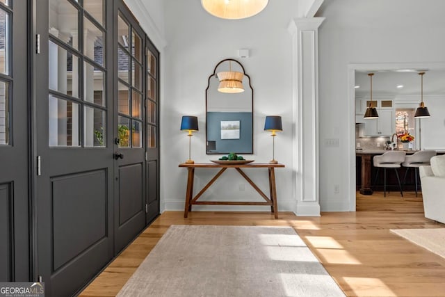 doorway with hardwood / wood-style floors and decorative columns