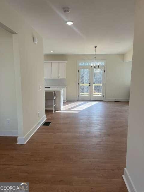 unfurnished dining area featuring dark hardwood / wood-style floors and french doors