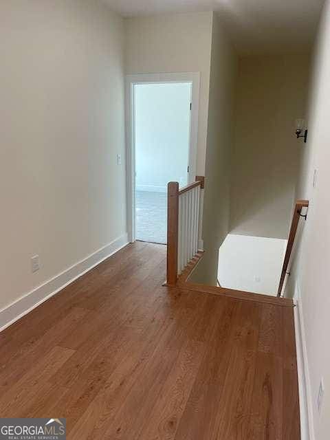 corridor with hardwood / wood-style flooring