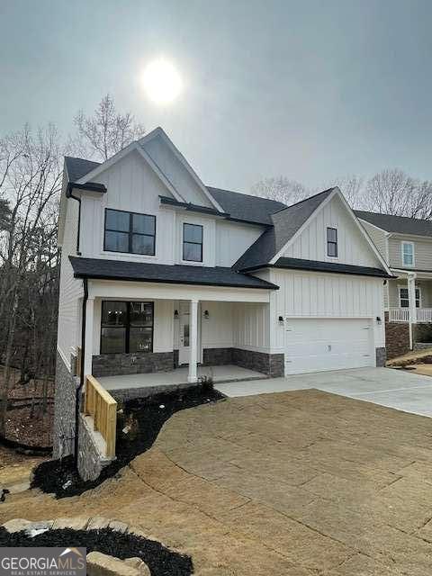 modern inspired farmhouse with a porch and a garage