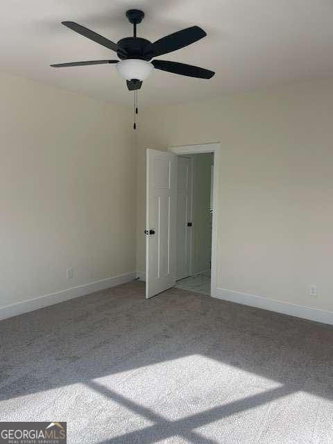 spare room with light carpet and ceiling fan