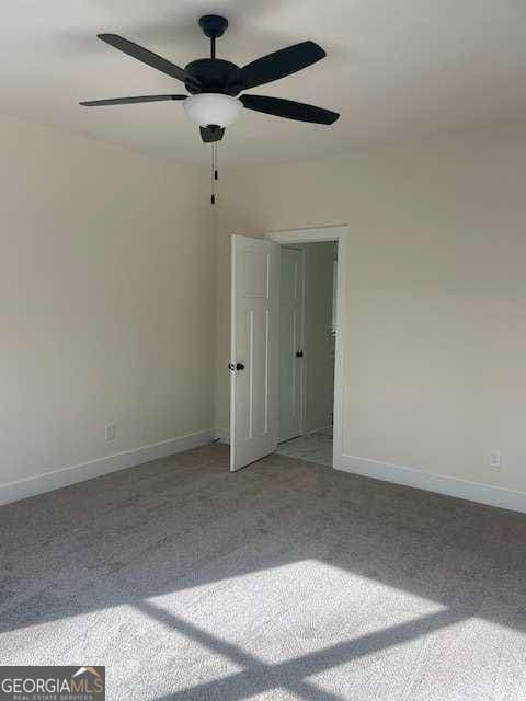 carpeted spare room with ceiling fan