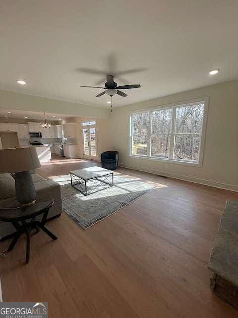 living room with ceiling fan and light hardwood / wood-style floors