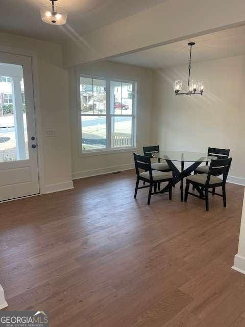 dining room featuring an inviting chandelier, plenty of natural light, and dark hardwood / wood-style flooring