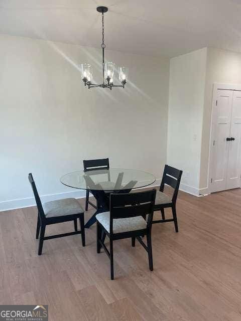 dining space featuring hardwood / wood-style flooring and a chandelier