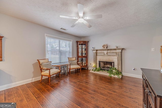 sitting room featuring a textured ceiling, dark wood-type flooring, and ceiling fan