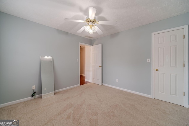 carpeted empty room featuring a textured ceiling and ceiling fan