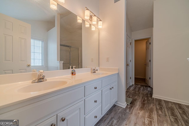 bathroom featuring vanity, hardwood / wood-style floors, and a shower with door