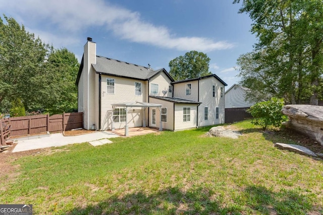 rear view of property featuring a lawn and a patio area