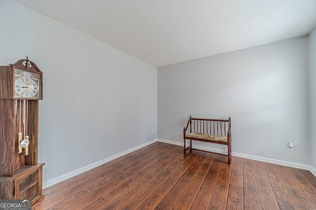 unfurnished room with dark wood-type flooring and a textured ceiling