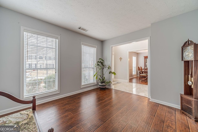 interior space with wood-type flooring and a textured ceiling