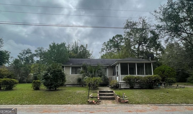 view of front of house featuring a sunroom and a front yard