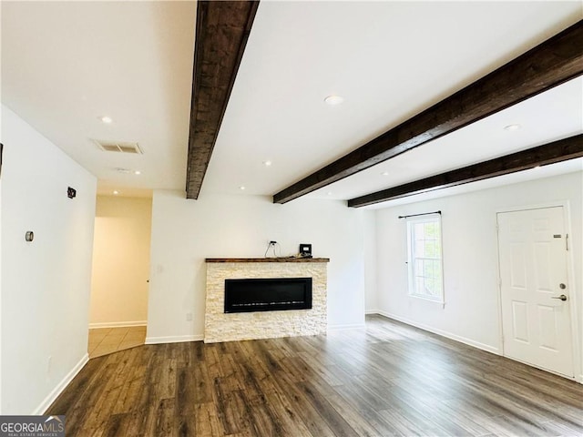 unfurnished living room with hardwood / wood-style flooring, a fireplace, and beam ceiling