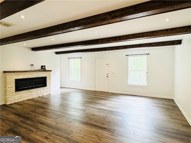 unfurnished living room with dark hardwood / wood-style floors, a fireplace, and beam ceiling