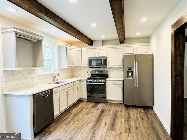 kitchen with stainless steel appliances, sink, and white cabinets