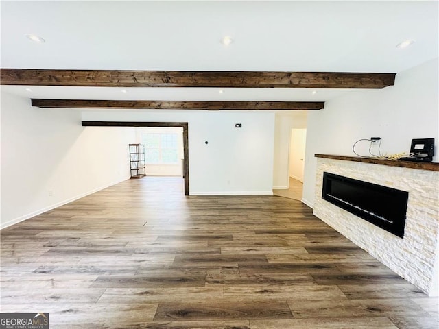 unfurnished living room with hardwood / wood-style flooring and beamed ceiling