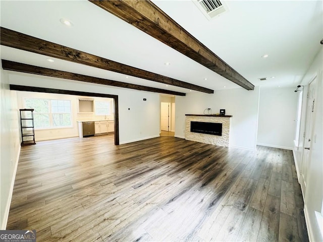 unfurnished living room with hardwood / wood-style floors and beam ceiling