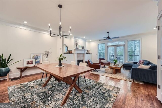 dining area featuring hardwood / wood-style floors, a notable chandelier, ornamental molding, and french doors