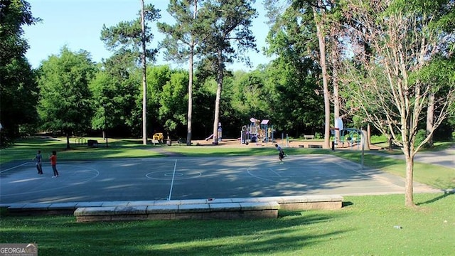 view of community featuring a playground, basketball court, and a lawn