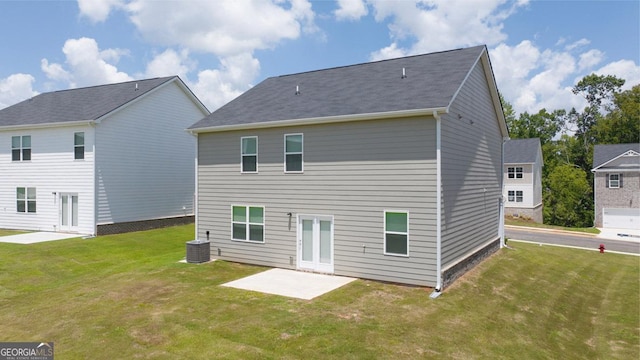 rear view of house featuring a yard, central AC, and a patio area