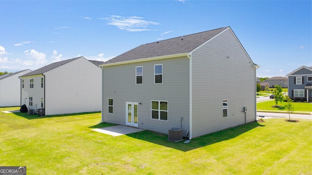 back of house with a lawn and central air condition unit