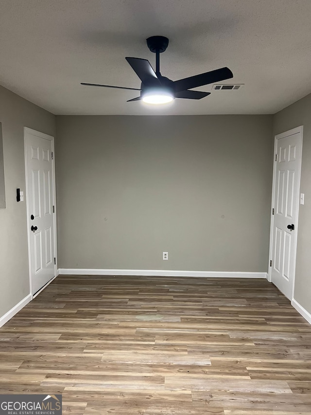 empty room featuring a textured ceiling, light hardwood / wood-style flooring, and ceiling fan