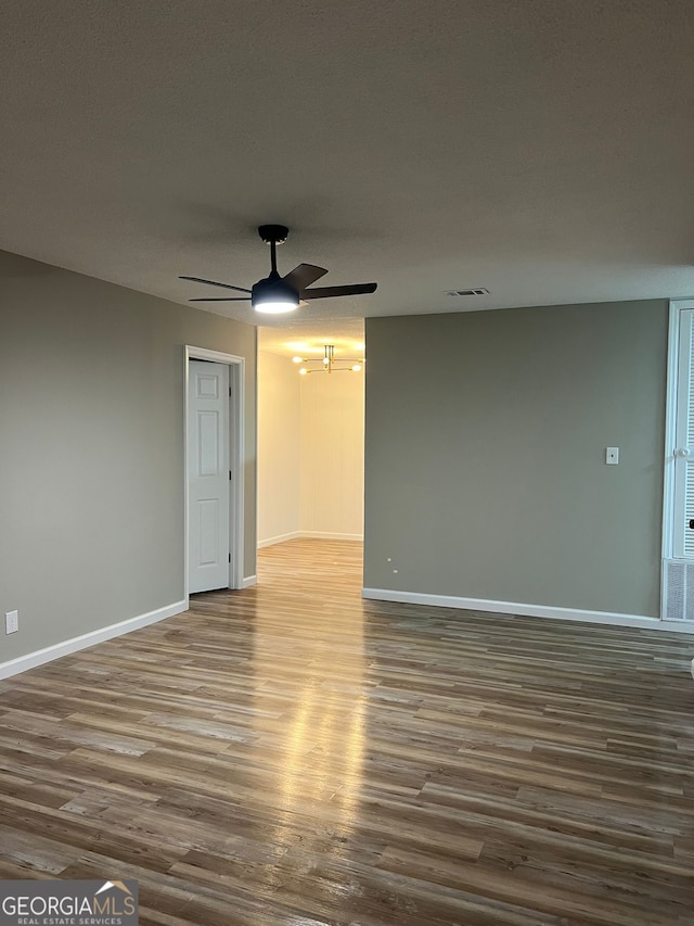 empty room with hardwood / wood-style floors and ceiling fan